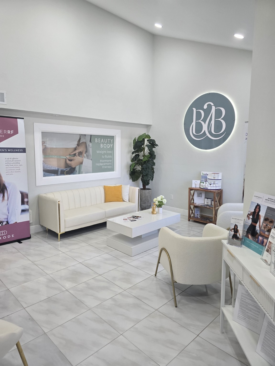 Bright waiting area with cream seating and the Beauty Body wall logo